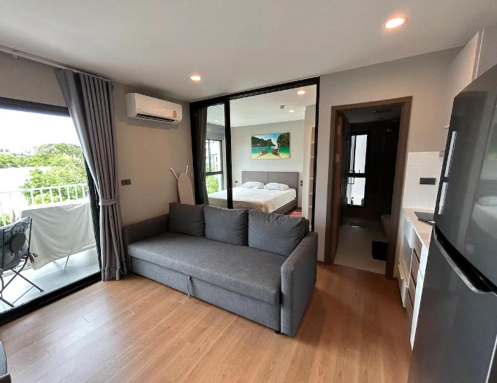 Una sala de estar con un sofá y un dormitorio. en Title Rent Rawai, en Rawai Beach
