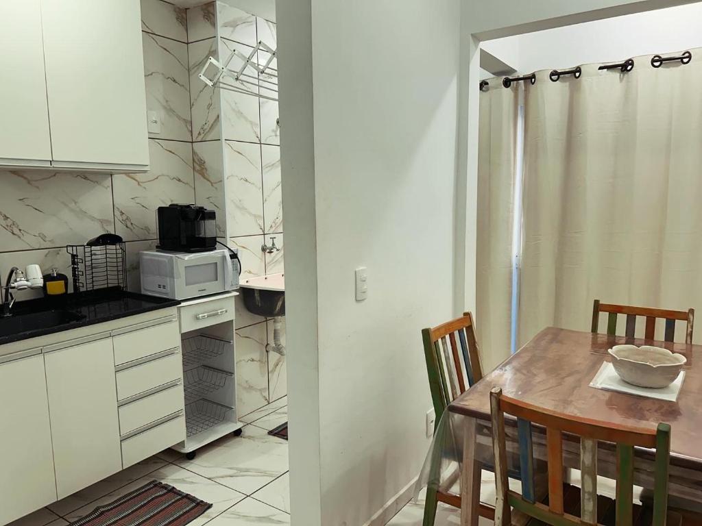 uma cozinha com uma mesa de jantar e um micro-ondas em Apart. Bela Vista em Porto Ferreira