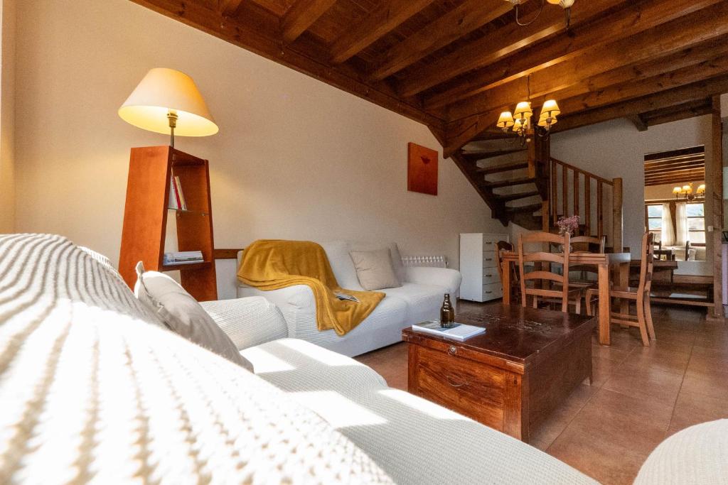 ein Wohnzimmer mit einem weißen Sofa und einem Tisch in der Unterkunft Apartamentos Rurales San Feliz in Pola de Lena