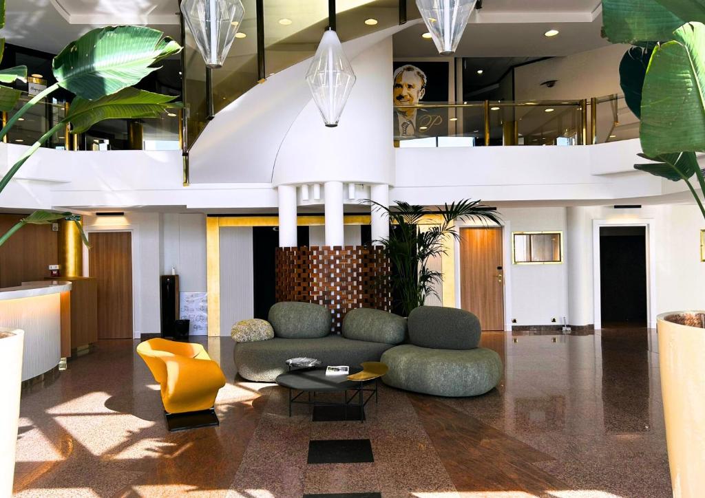 een lobby met een bank en een tafel en planten bij Hotel Palladia in Toulouse