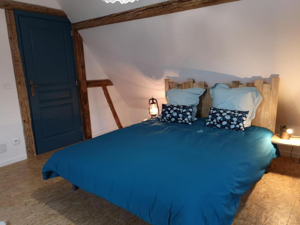 a bedroom with a blue bed with blue sheets and pillows at Au 19 de Lina in Hoerdt
