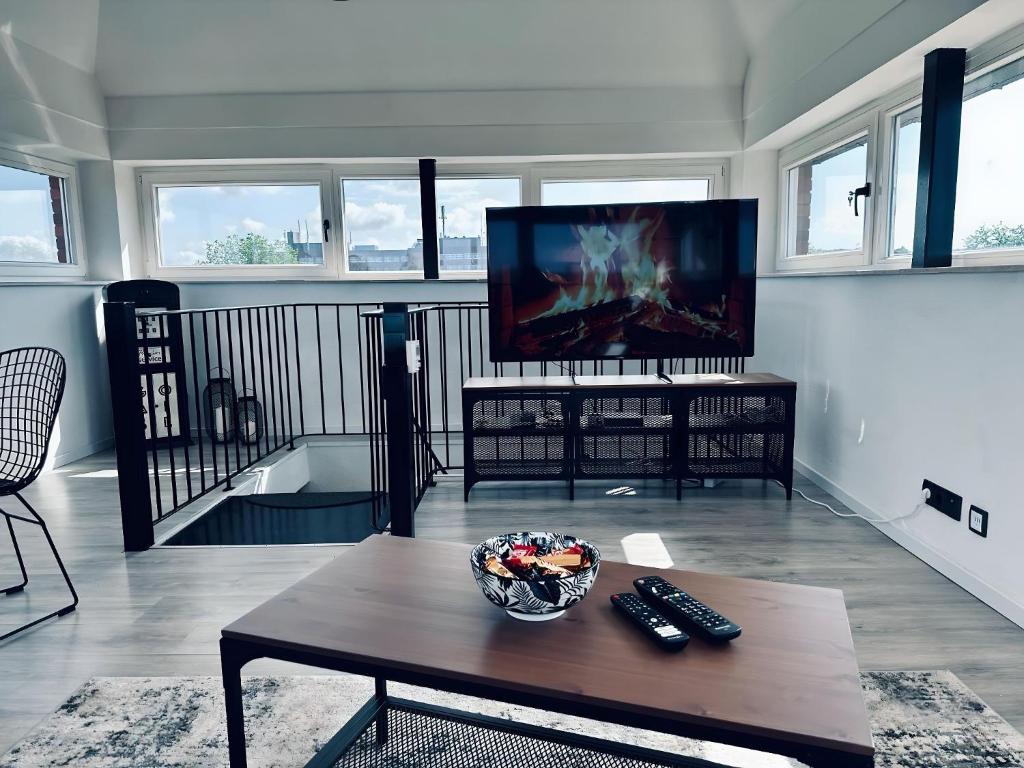 ein Wohnzimmer mit einem TV und einem Couchtisch in der Unterkunft Apartment 360 Grad mit direktem Blick aufs Schloss in Steinfurt