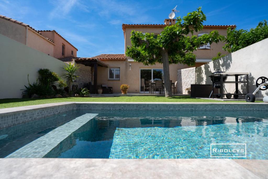 - une piscine en face d'une maison dans l'établissement Vias Plage - Villa avec piscine privé, à Vias