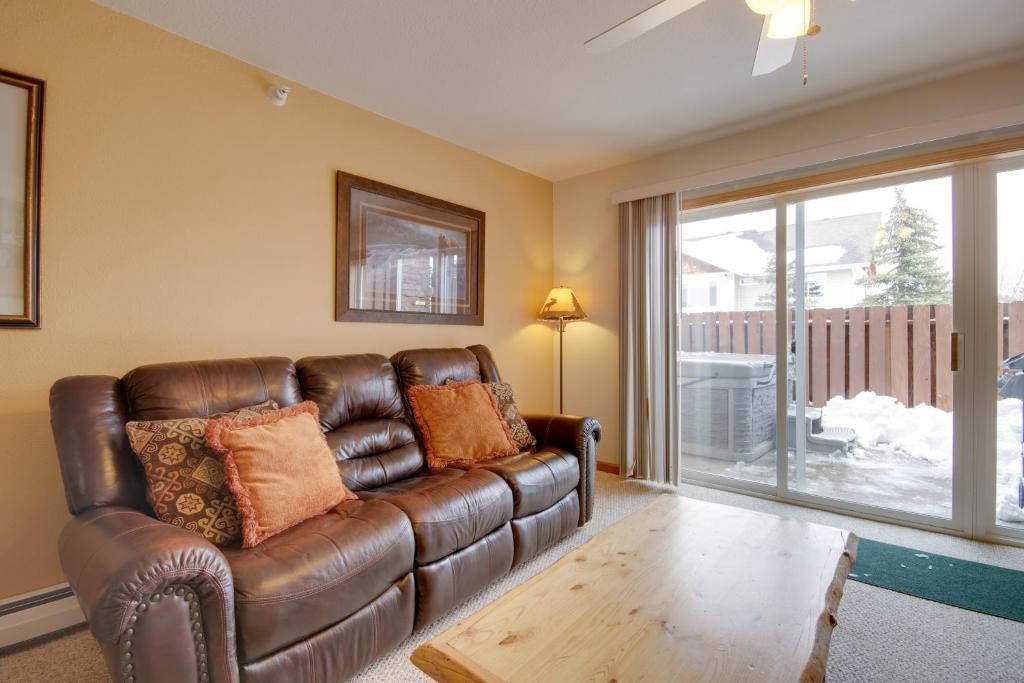 a leather couch in a living room with a sliding glass door at Condo in Cedar Creek with Shuttle to Big Sky Resort! in Gallatin Gateway