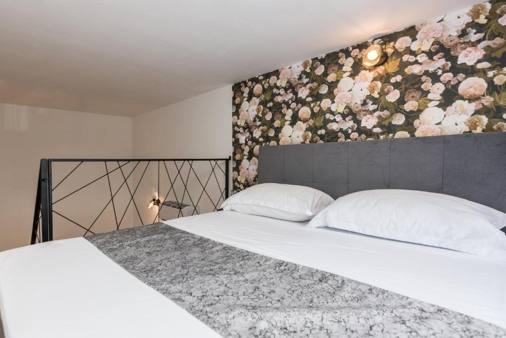 sypialnia z łóżkiem z kwiatową ścianą w obiekcie Apartments Tija Exclusive w mieście Zadar