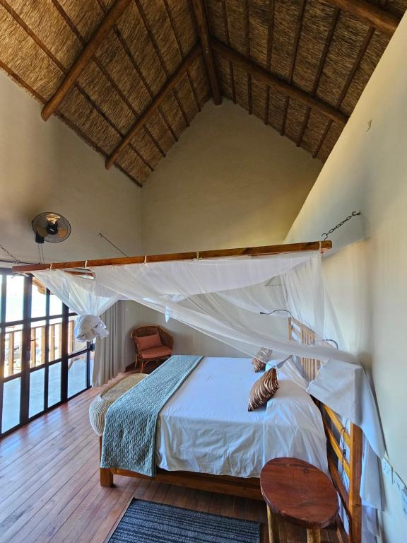 a bedroom with a bed and a wooden floor at Joma Adventure Lodge in Senga