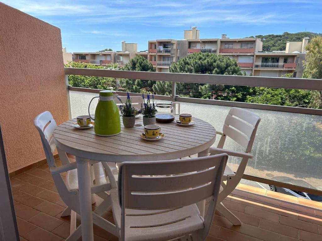une table et des chaises sur un balcon avec vue sur une ville dans l'établissement Duplex climatisé avec 2 terrasses, garage, à 200m de la plage et proche commerces - Bormes-les-Mimosas - FR-1-251-733, à Bormes-les-Mimosas