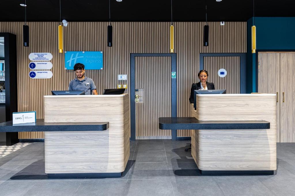 two people are standing behind the counter of a store at Holiday Inn Express Ajaccio by IHG in Ajaccio