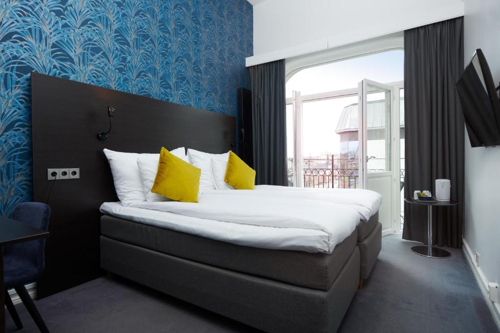 sypialnia z dużym łóżkiem z żółtymi poduszkami w obiekcie Clarion Collection Hotel Plaza w mieście Karlstad