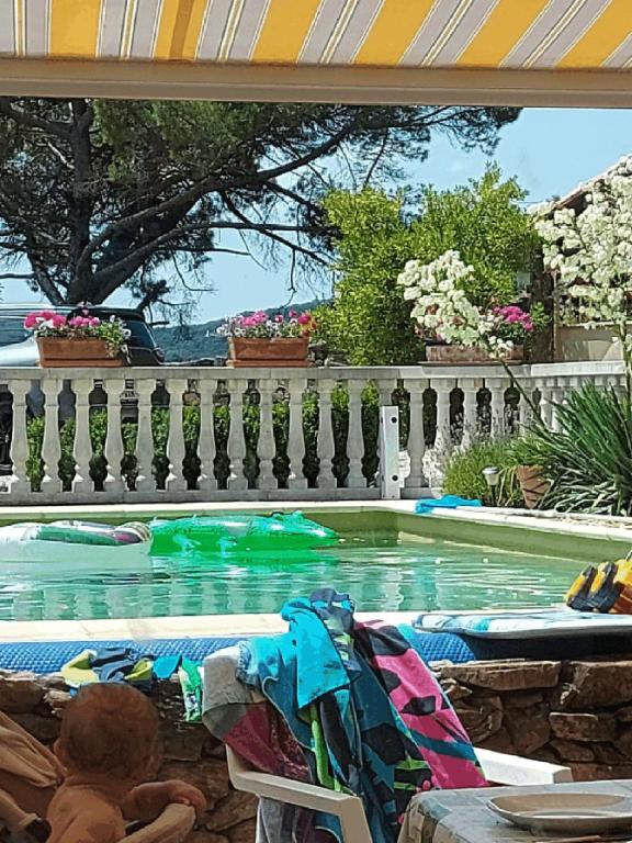 un enfant allongé sur une chaise dans une piscine dans l'établissement Villla La Label, à Notre-Dame-de-la-Rouvière
