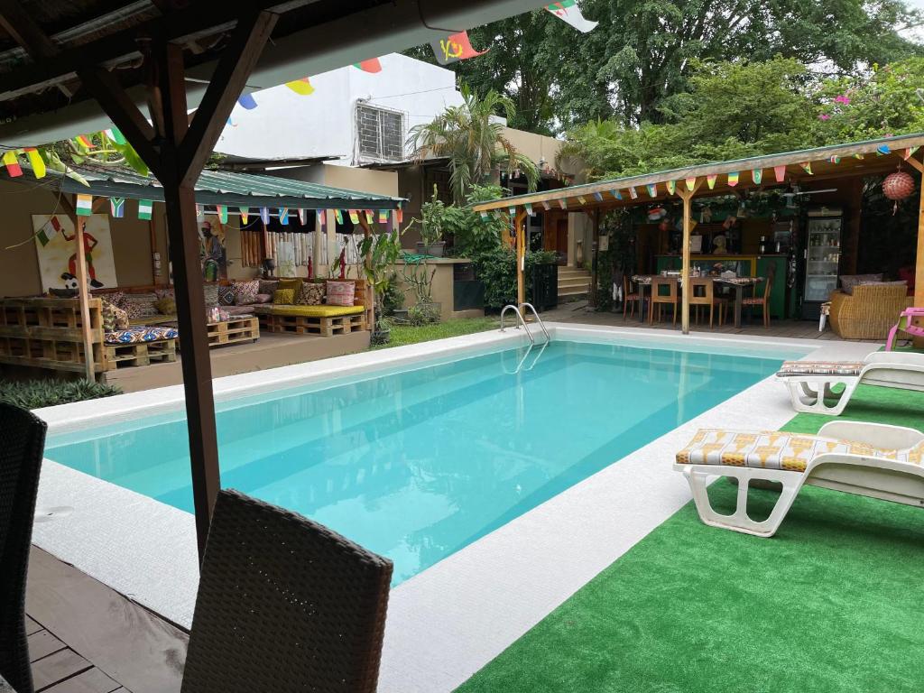 a swimming pool with two chairs and a table at Villa Mango in Abidjan