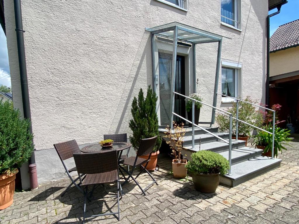 a patio with a table and chairs and potted plants at Ferienwohnung Schmid Lautrach im Illerwinkel in Lautrach