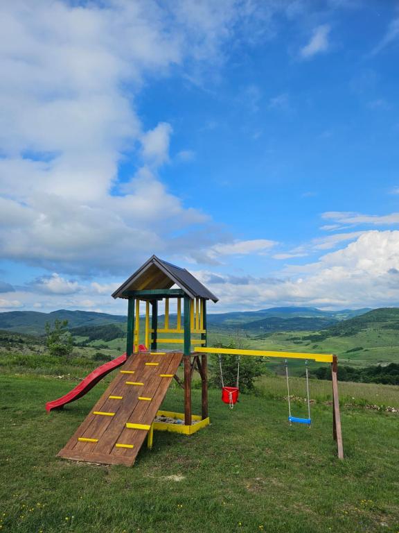 een speeltuin met een glijbaan en een schommel bij Under Sky House - Vikendica - Manjača in Ključ