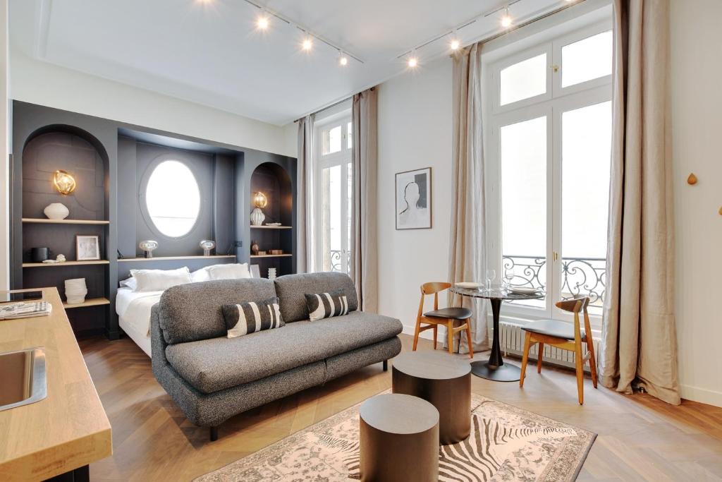 un salon avec un canapé et un lit dans l'établissement Magnifique Studio Montorgueil, à Paris