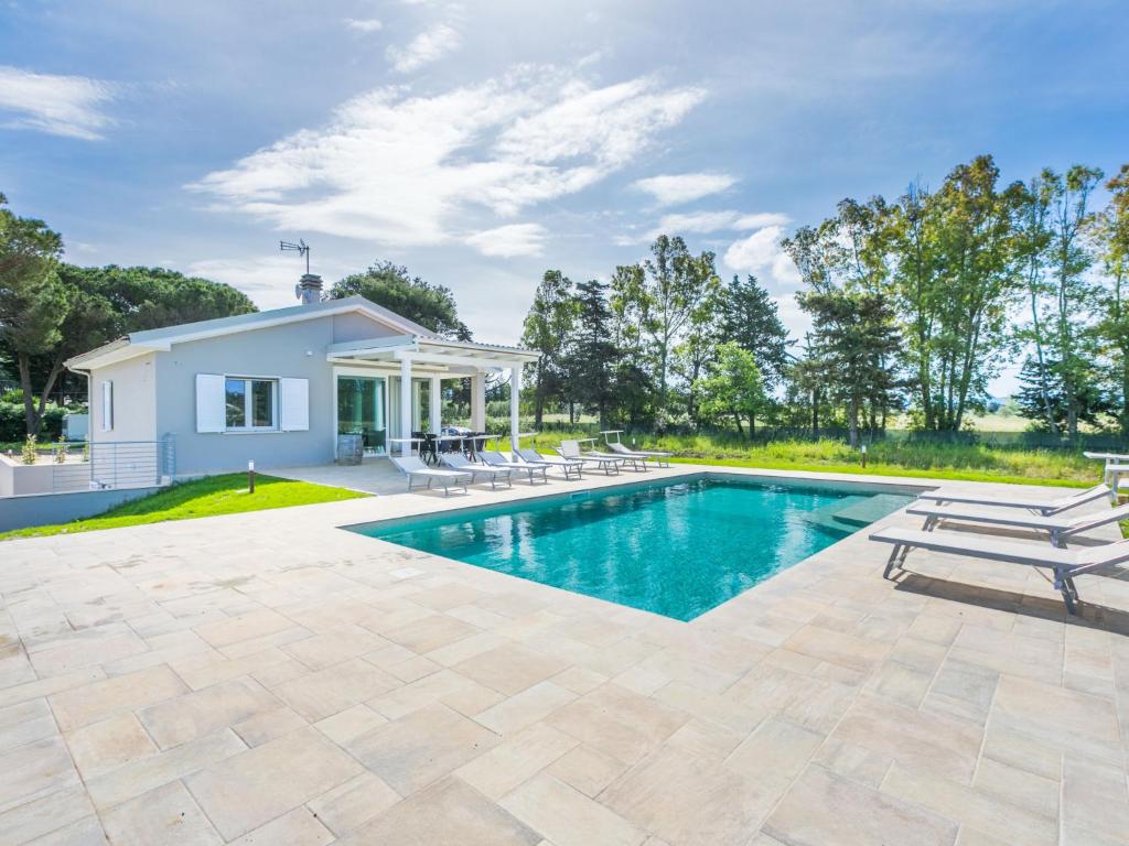 a swimming pool in the backyard of a home with a house at Holiday Home Veronica by Interhome in Cecina