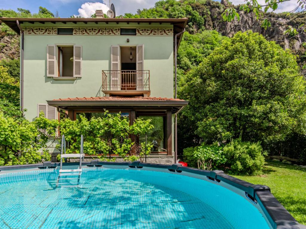 a villa with a swimming pool in front of a house at Holiday Home La Rina by Interhome in Dervio