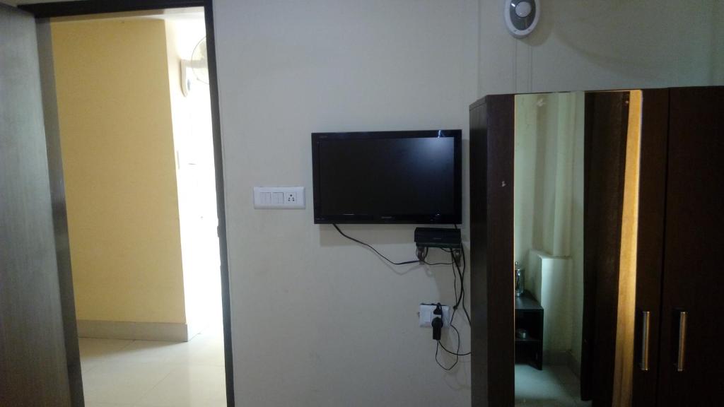 a flat screen tv on a wall in a room at Hotel Sunshine in Kāshīpur