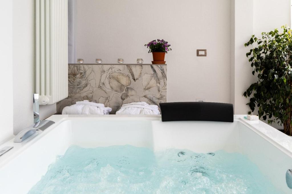a bath tub with a black chair in a room at Le Suite di Magda Relax & Rooms in Polignano a Mare