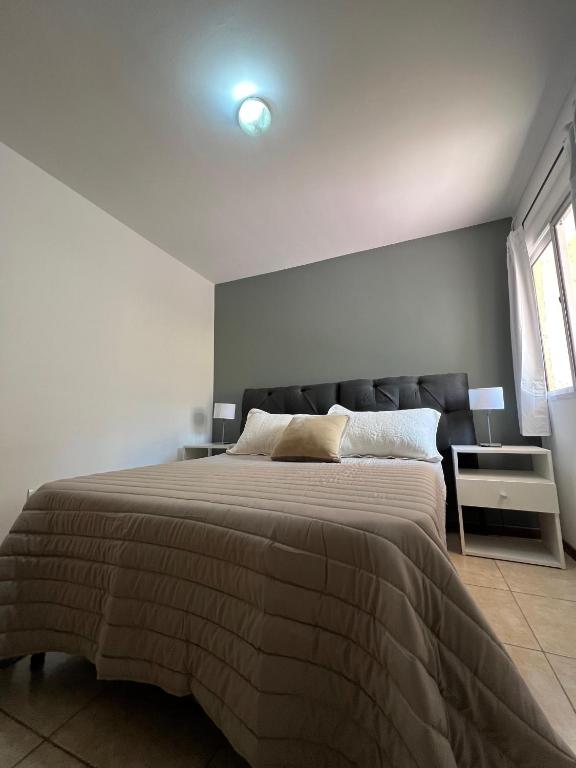 Un dormitorio con una cama grande y una ventana en Portal de Dorrego, en Guaymallén