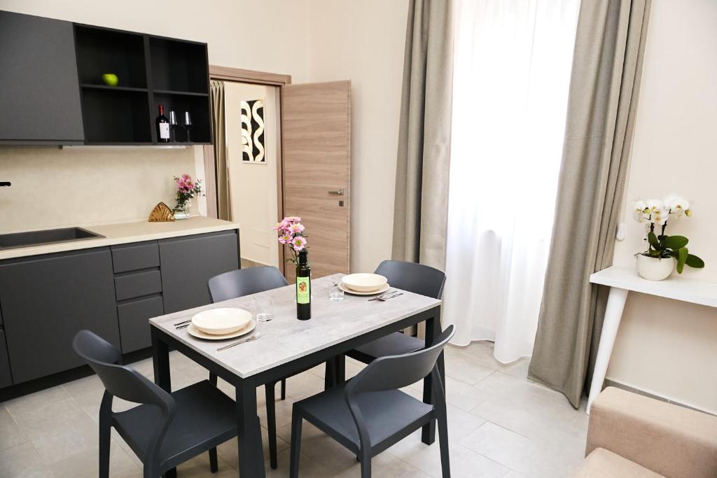 a kitchen and dining room with a table and chairs at Casa Altarocca - Home Design in Tarquinia