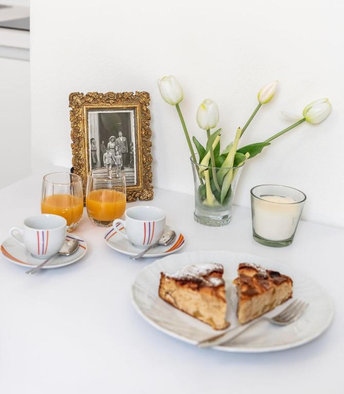a table with a plate of cake and coffee and flowers at Borgo dei Nonni - Menaggio by LoveComo in Menaggio