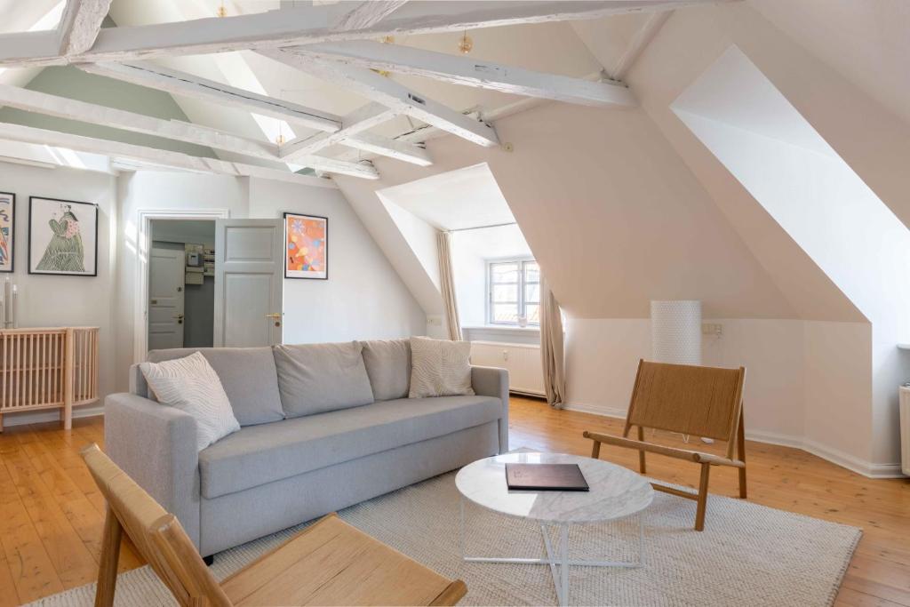 een woonkamer met een bank en een tafel bij Unique Apartment w Exposed Beams Next to Tivoli in Kopenhagen