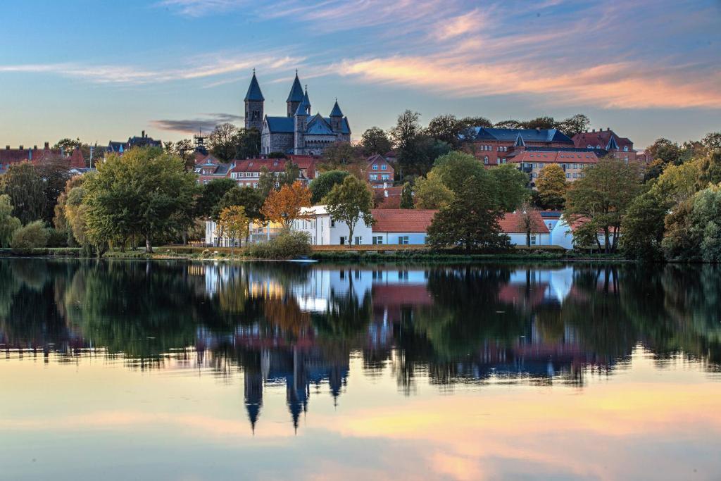Blick auf die Stadt von gegenüber auf einen See in der Unterkunft Golf Hotel Viborg in Viborg
