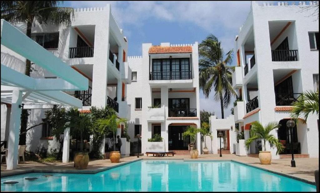a swimming pool in front of a building at Wayside Beach Apartments in Diani Beach