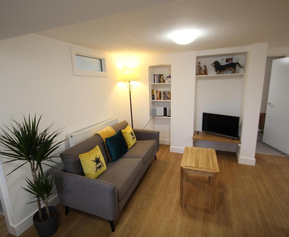 a living room with a couch and a table at The Garden Apartment in Newton Abbot