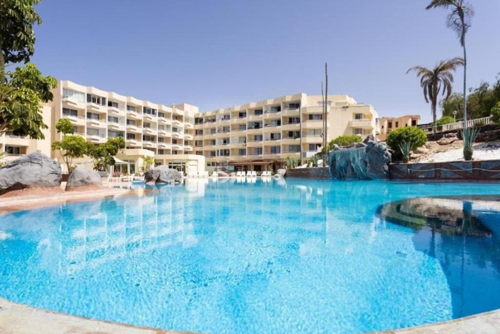 una gran piscina frente a un hotel en Amplio estudio Golf del Sur en San Miguel de Abona