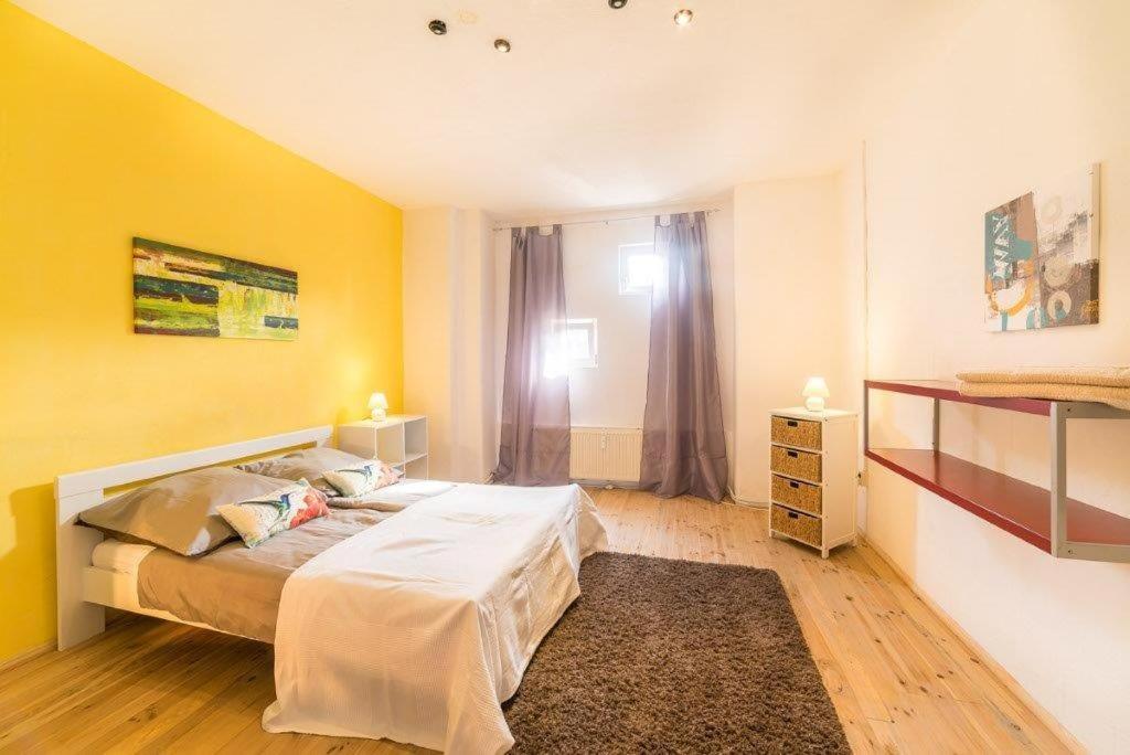 - une chambre avec un lit et un mur jaune dans l'établissement Dresden Lofts, à Heidenau