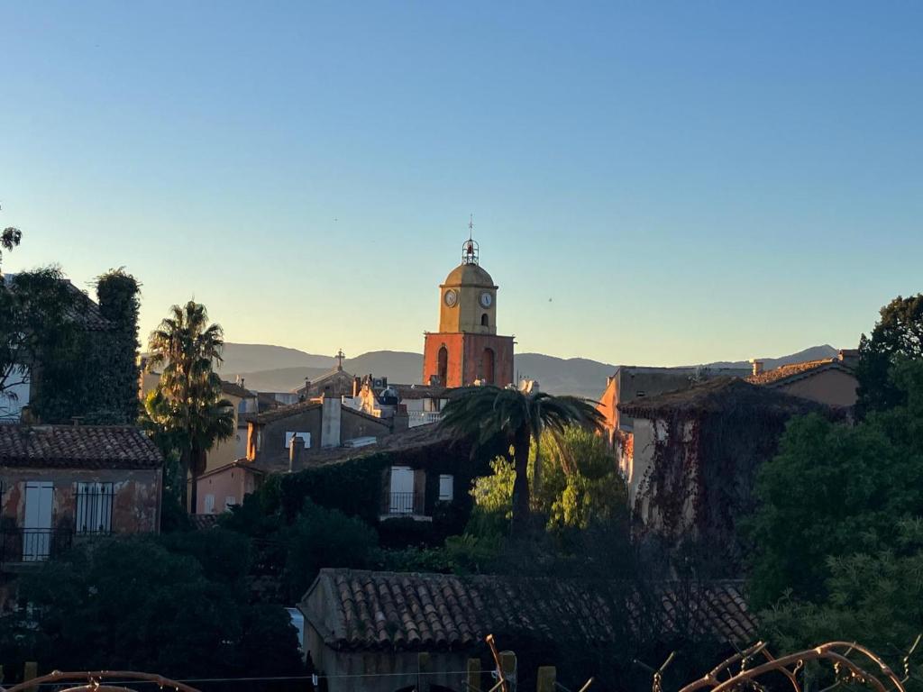 un bâtiment avec une tour d'horloge dans une ville dans l'établissement Au cœur de St Tropez, à Saint-Tropez