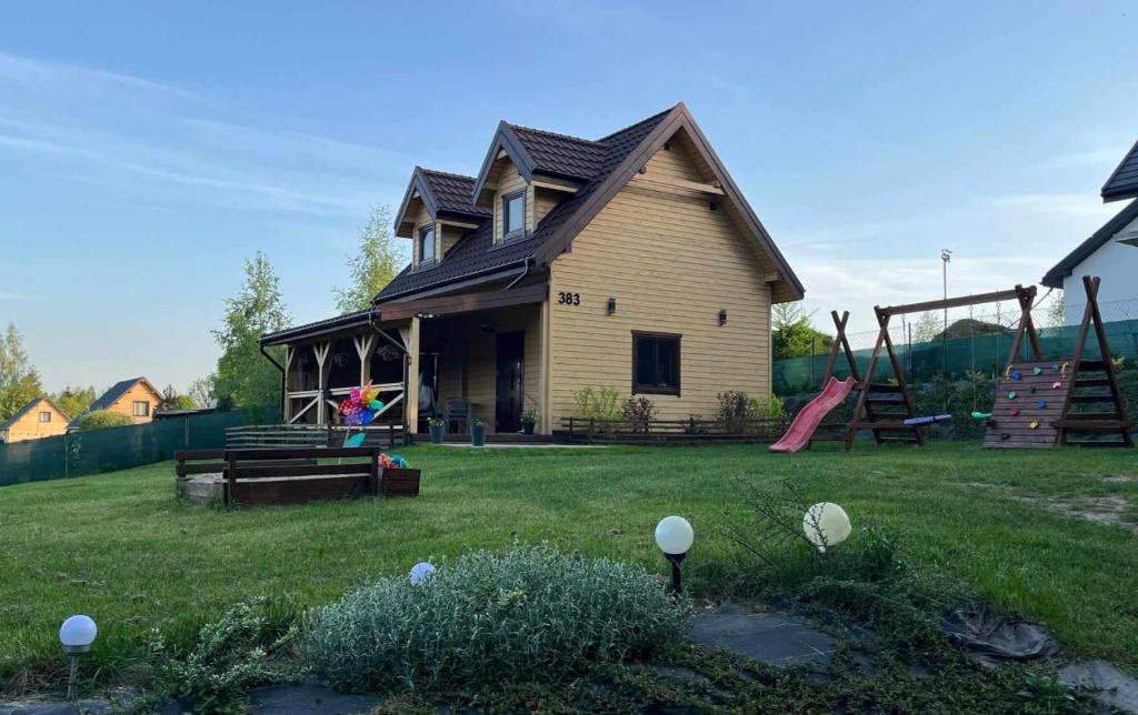 uma casa com um parque infantil no quintal em Domek pod Dębami Bogaczewo em Bogaczewo
