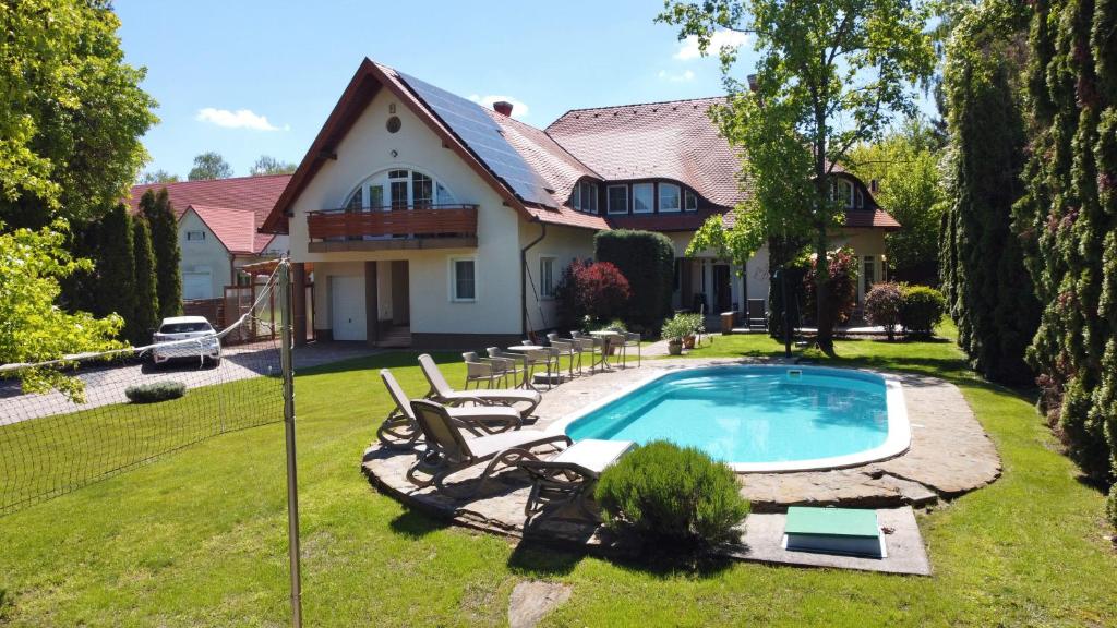 a house with a swimming pool in the yard at Künszler Apartmanház in Zamárdi