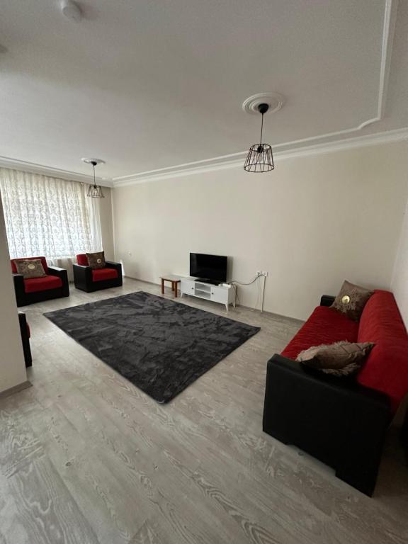 特拉布宗的住宿－Trabzon Meydanın Göbeğinde Kiralık Daire，客厅配有红色沙发和电视