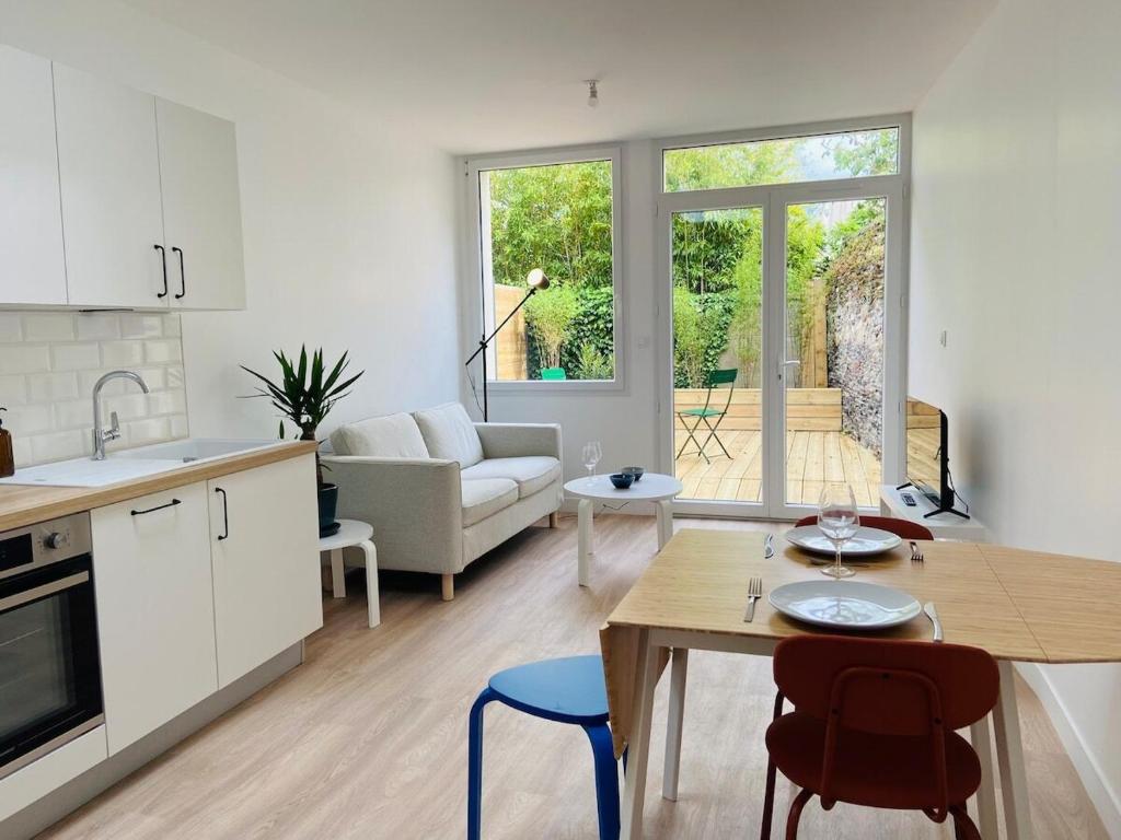 une cuisine et un salon avec une table et des chaises dans l'établissement Casa Gardot, à Angers