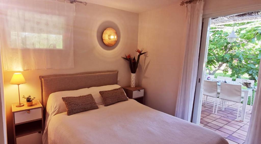 1 dormitorio con 1 cama y ventana con patio en Lou Pitchoun, en Saint-Aygulf