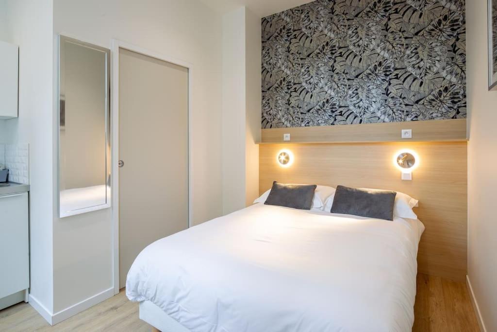 une chambre avec un lit blanc avec deux oreillers dessus dans l'établissement Appartement 3 proche de la gare et du centre ville, à Amiens