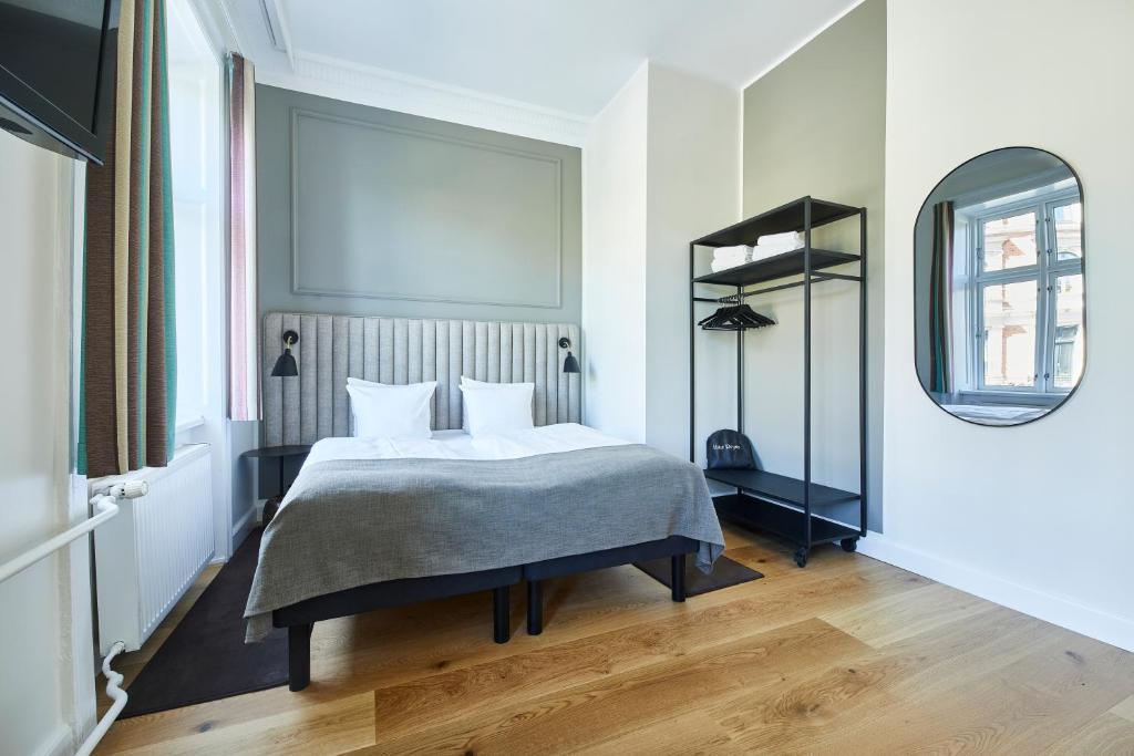 sypialnia z łóżkiem i lustrem w obiekcie Hotel Sct. Thomas w Kopenhadze