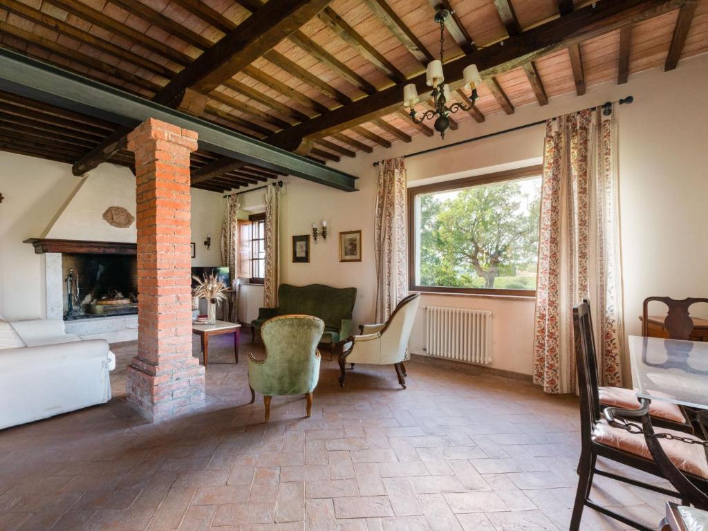salon z dużym oknem i kominkiem w obiekcie Holiday Home Poggio Campana by Interhome w mieście Montemerano