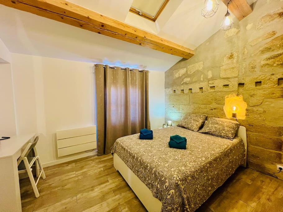une chambre avec un lit et un mur en bois dans l'établissement La Peiro Malo - Charmant Duplex Centre Historique-CLIM-4 personnes, à Istres