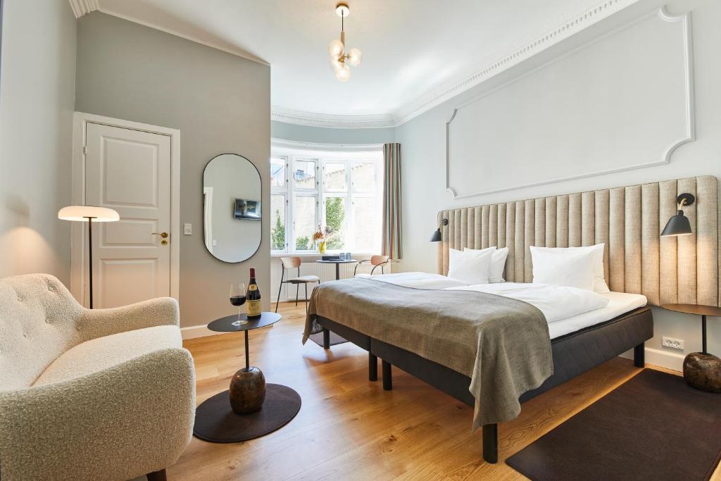 Habitación de hotel con cama y silla en Hotel Sct. Thomas en Copenhague