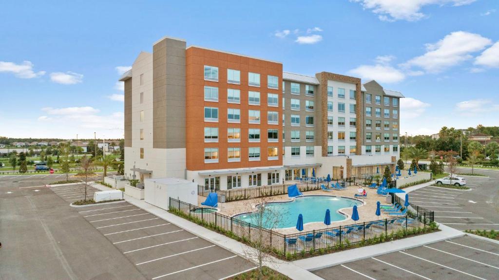um edifício de apartamentos com uma piscina em frente a um edifício em Holiday Inn Express & Suites Orlando- Lake Buena Vista, an IHG Hotel em Orlando