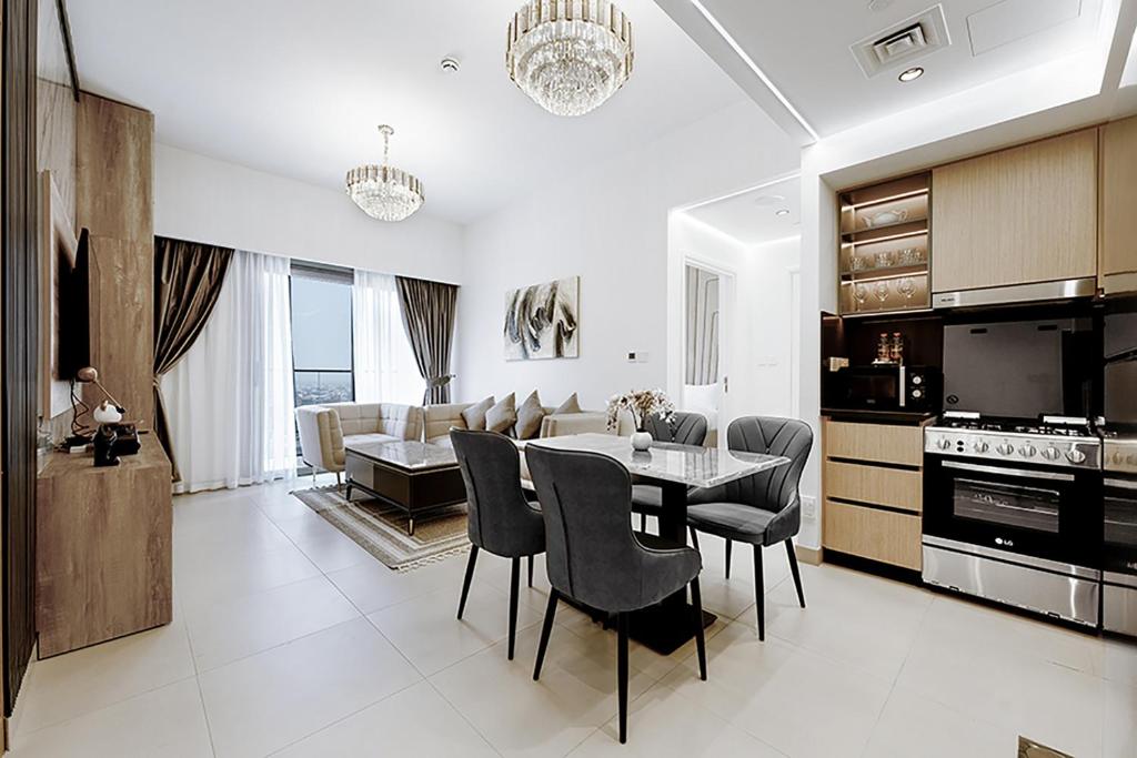 uma cozinha e sala de estar com mesa e cadeiras em Stayis -Spacious & Luxury 1 Bedroom room Apartment em Dubai