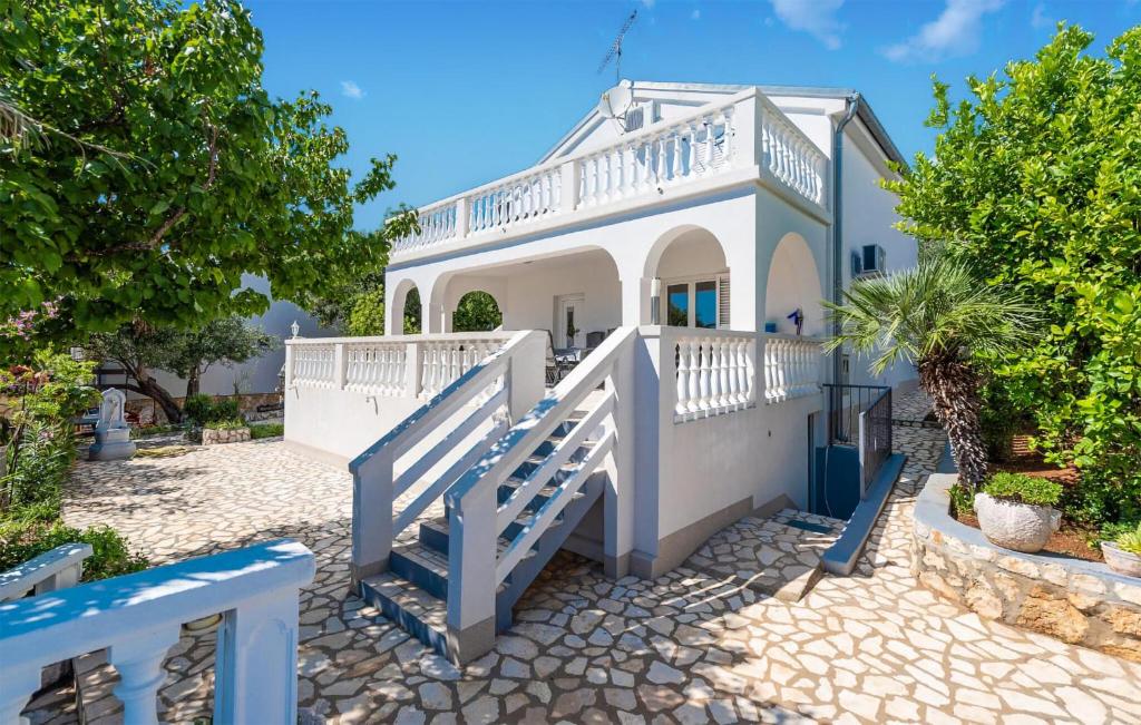 a white house with a staircase leading up to it at Beautiful Apartment In Potocnica in Potocnica