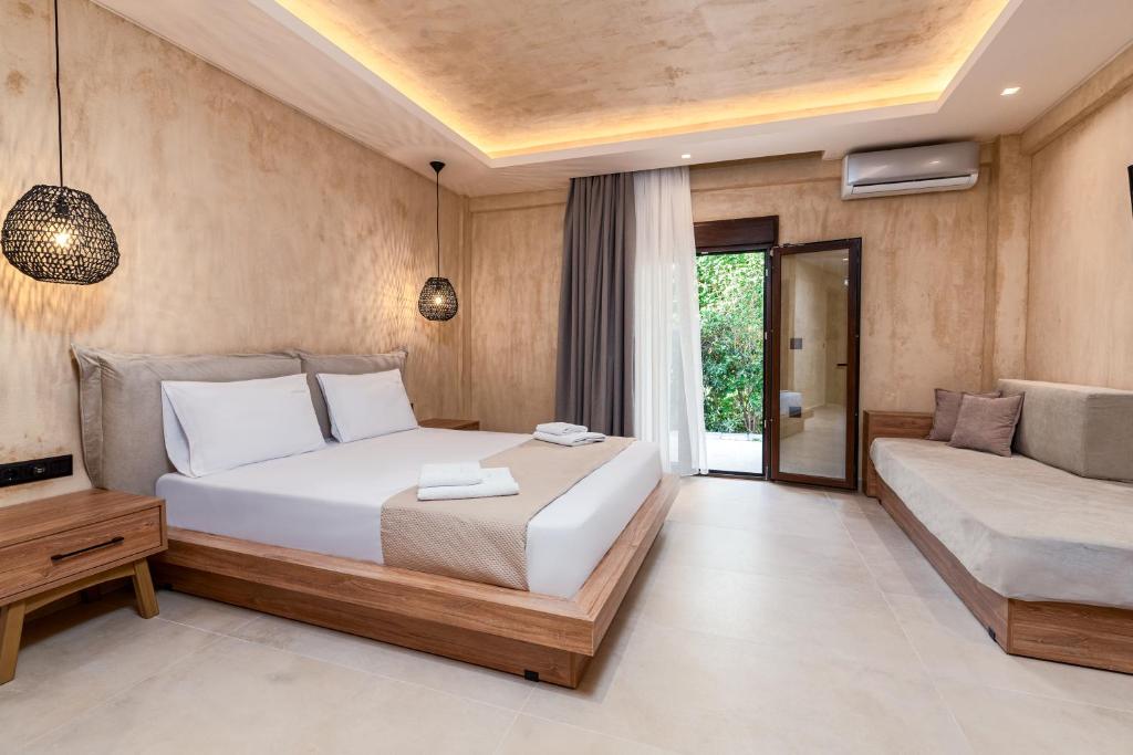 a bedroom with a large white bed and a couch at Odyssey Accommodation - Apartments in Pefkochori