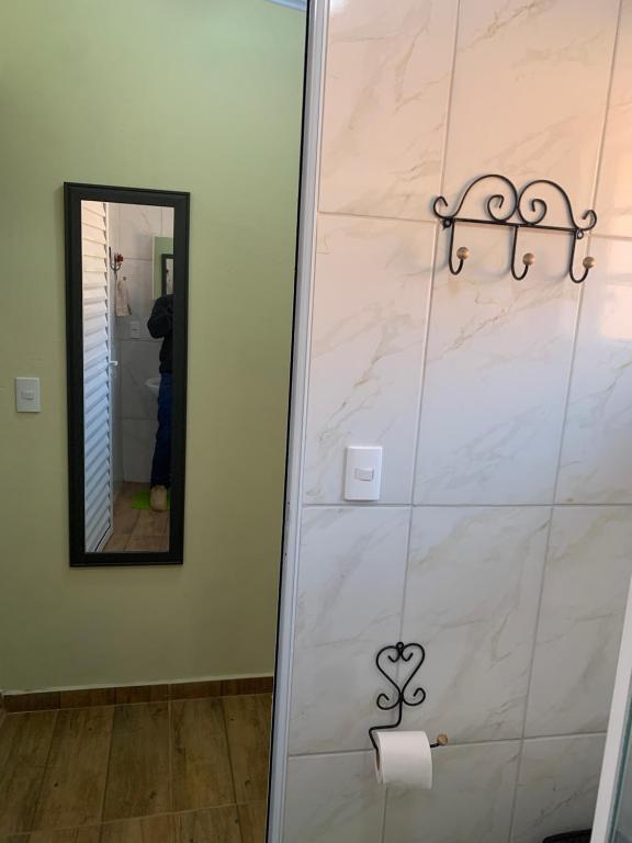 e bagno con specchio e rotolo di carta igienica. di Pousada Quinzitão - O seu local de descanso! a Extrema