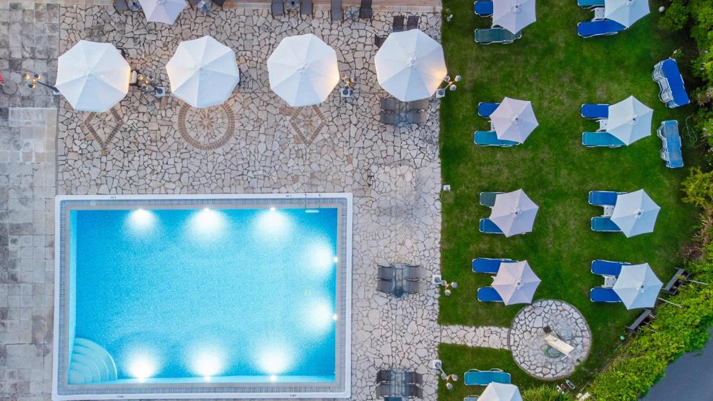 an overhead view of a pool with white umbrellas at Primavera Hotel in Dassia