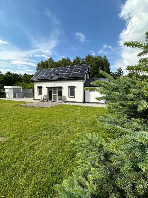 een wit huis met zonnepanelen erop bij Dom z sauną na wyłączność in Drawno