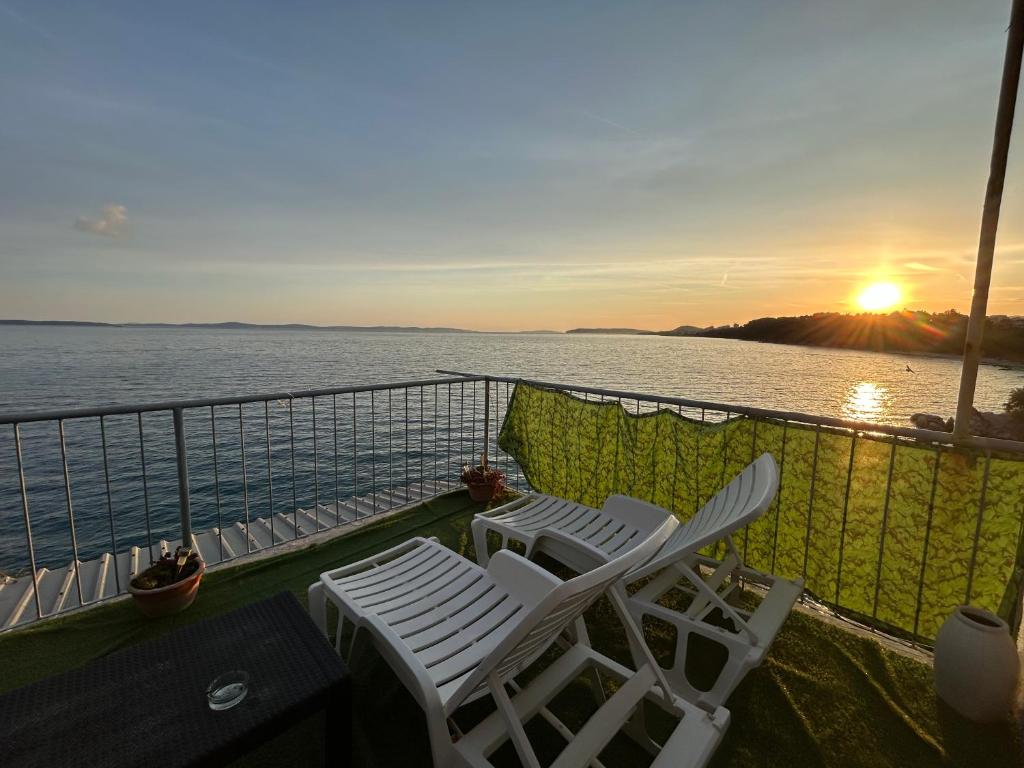 two chairs on the balcony of a cruise ship with the sunset at Apartment Kuk in Split